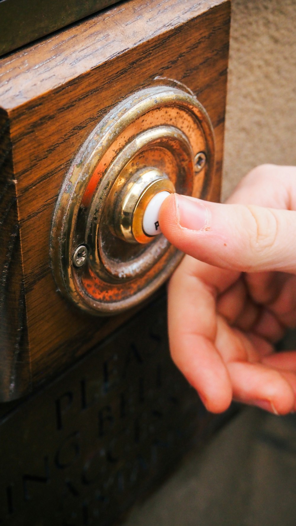 a person pressing a button on a wooden door