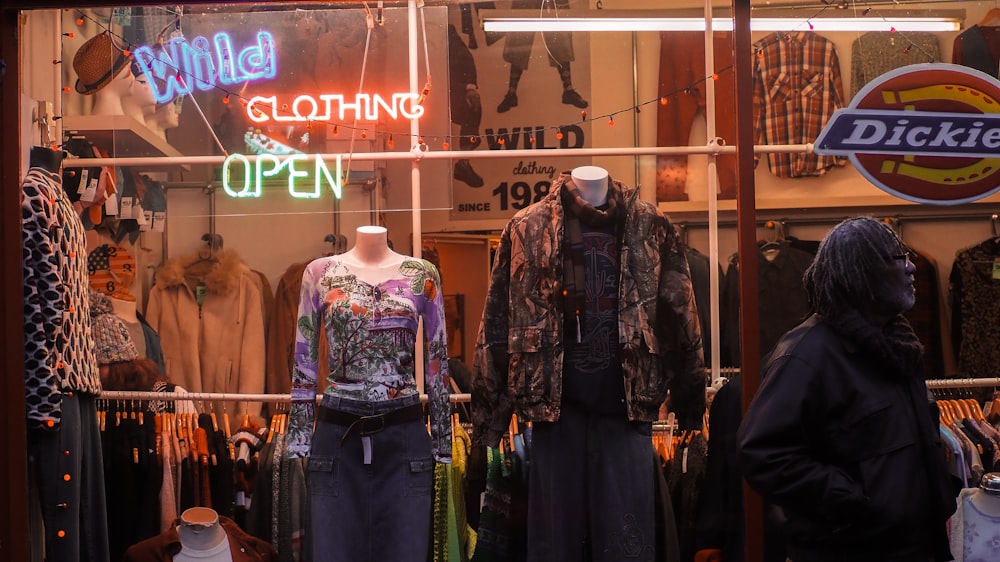 a clothing store window with mannequins in the window