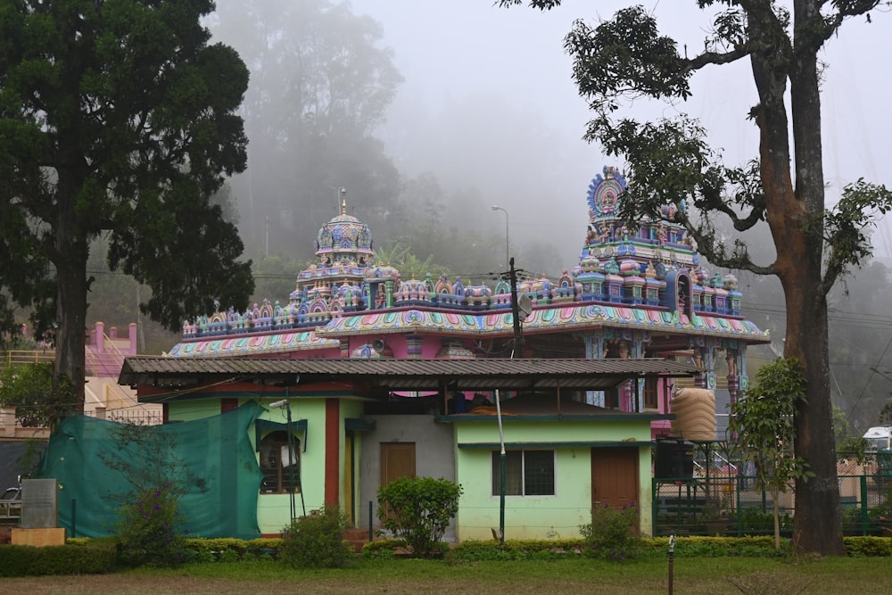 a colorfully painted building in the middle of a park