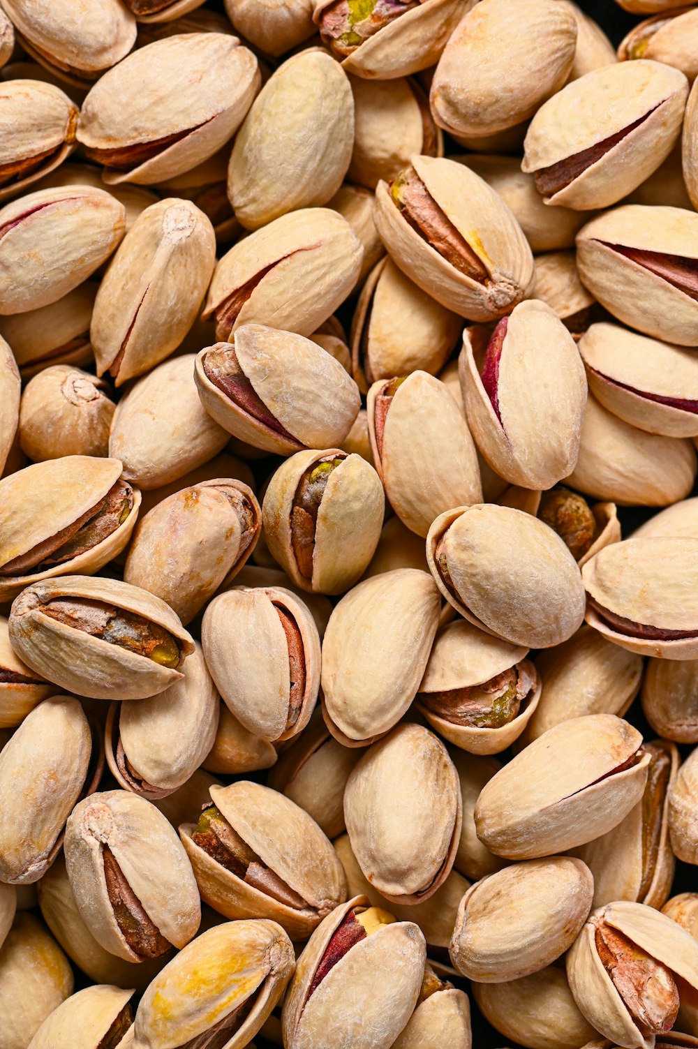 a pile of pistachio nuts sitting on top of each other