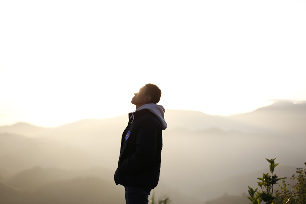 a man standing on top of a lush green hillside