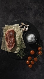 a piece of meat sitting on top of a black plate