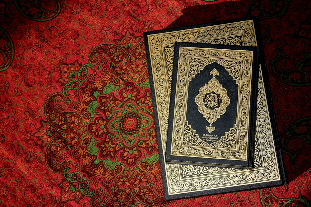 two books sitting on top of a red carpet