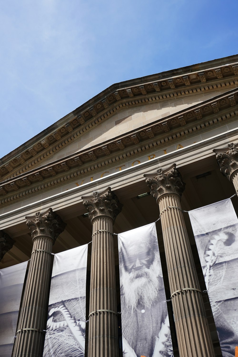 a building with four pillars and a large picture of a man on it