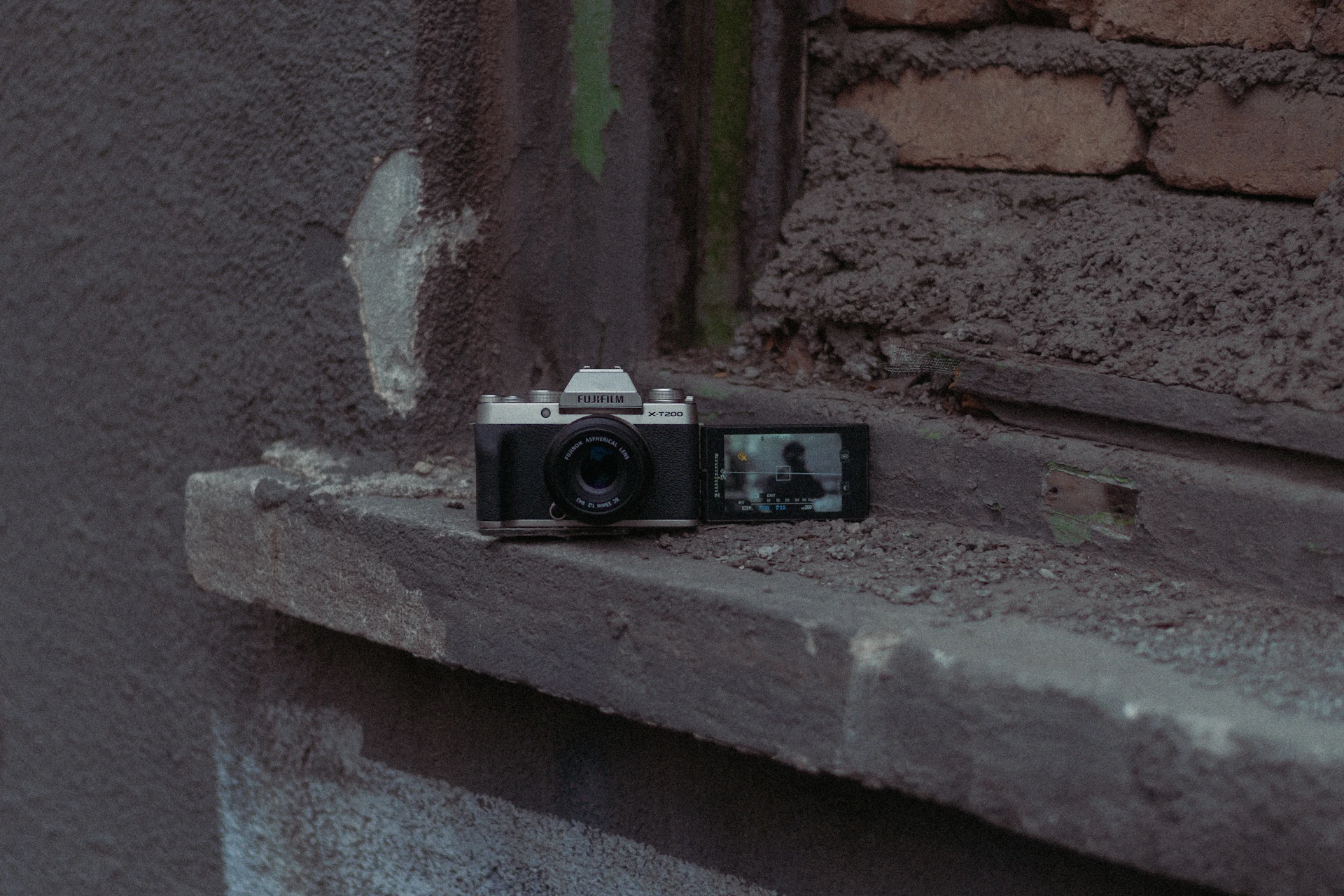 a camera sitting on a ledge in front of a brick wall