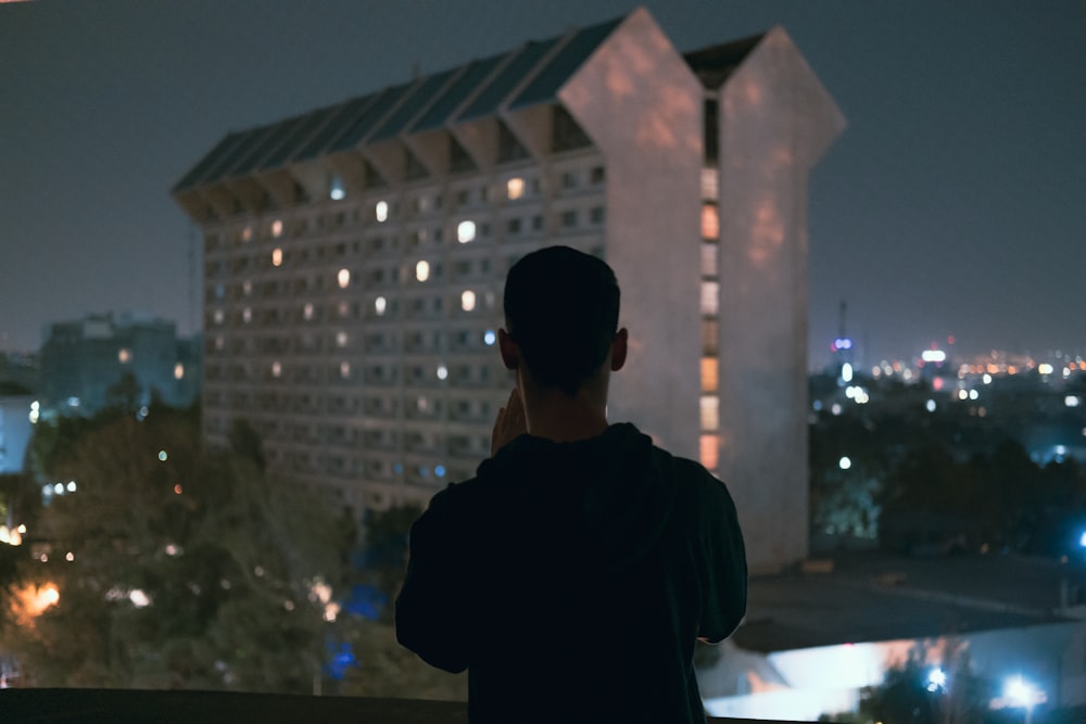 a man standing in front of a building at night