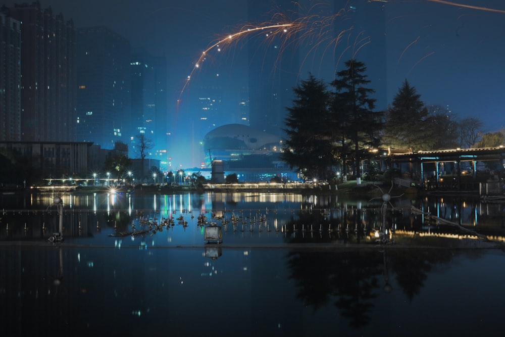 fireworks are lit up in the night sky over a lake