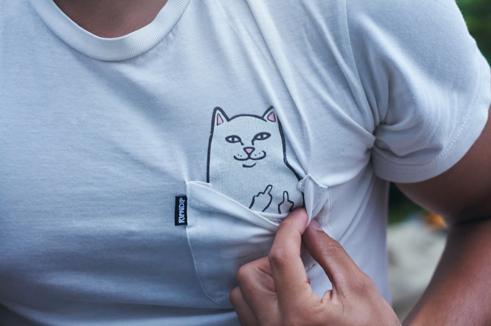 a person wearing a white shirt with a cat on it