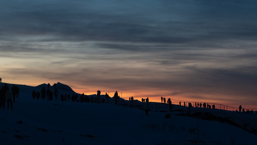 a group of people standing on top of a snow covered slope