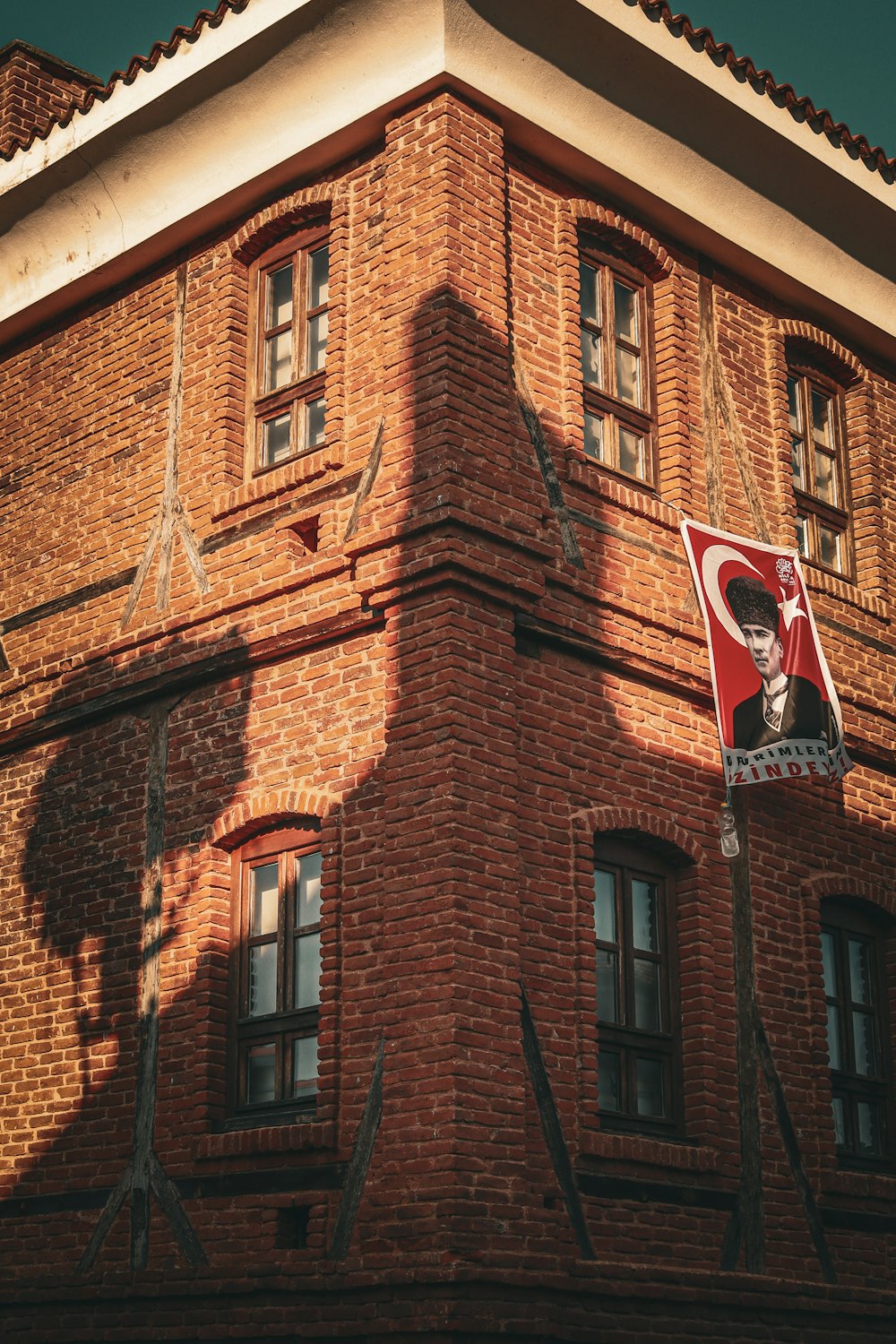 a red brick building with a red and white flag hanging from it's side