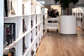 a room filled with lots of white shelves filled with books