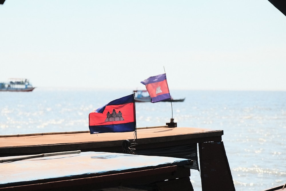 two flags on a boat near the ocean