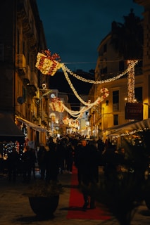 a city street is lit up with christmas lights