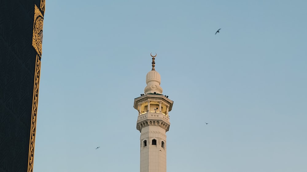 a tall white tower with a clock on it's side