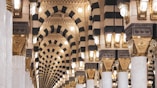 a hallway in a large building with columns and lights