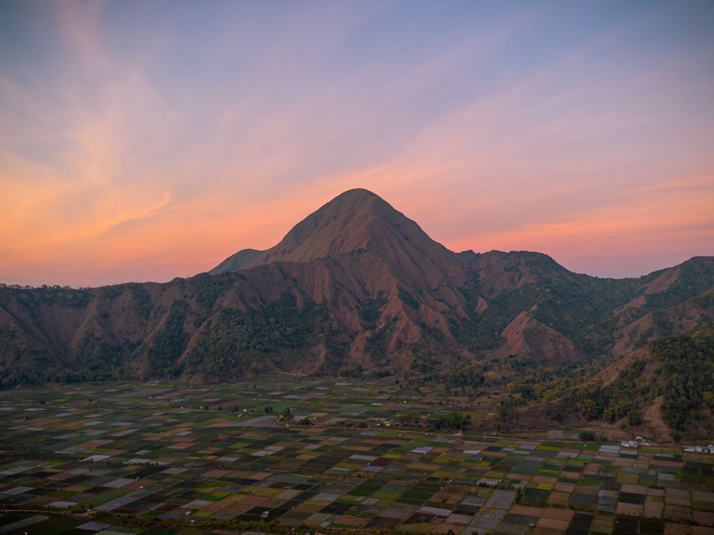 Una vista de una montaña con una puesta de sol al fondo