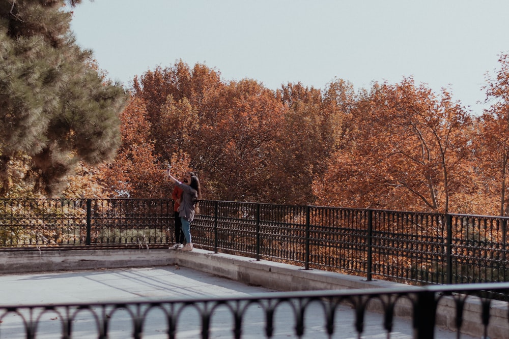 a couple of people standing on top of a bridge