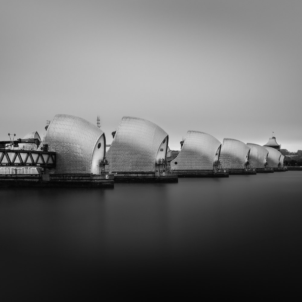 a black and white photo of a building on the water