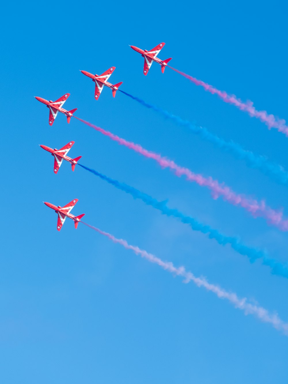 um grupo de jatos vermelhos e brancos voando em formação