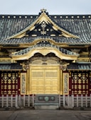 a building with a gold door and a black roof