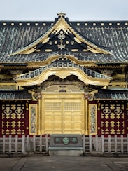 a building with a gold door and a black roof