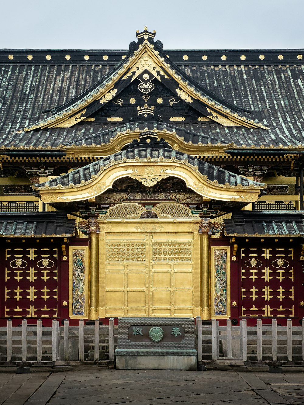 a building with a gold door and a black roof