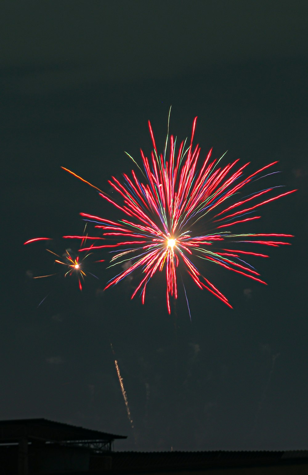 a red and white firework in the night sky