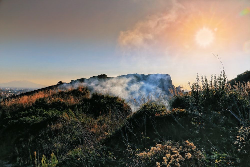 a cloud of smoke rising from the top of a mountain