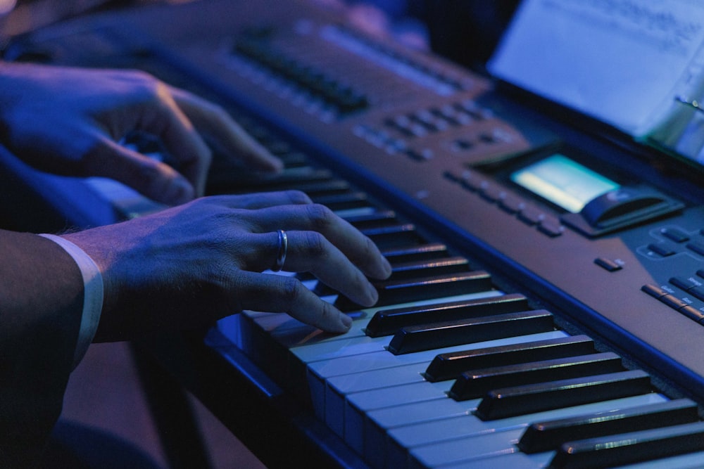 a person playing a musical instrument in front of a laptop