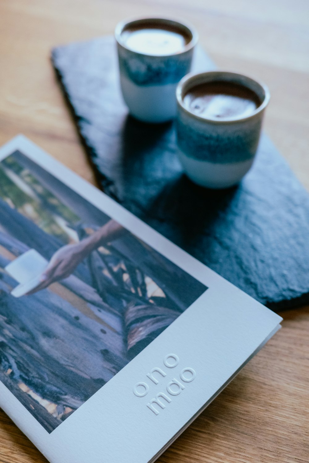 two cups of coffee sitting on top of a wooden table