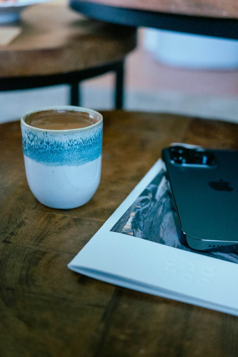 a cup of coffee next to an ipad on a table