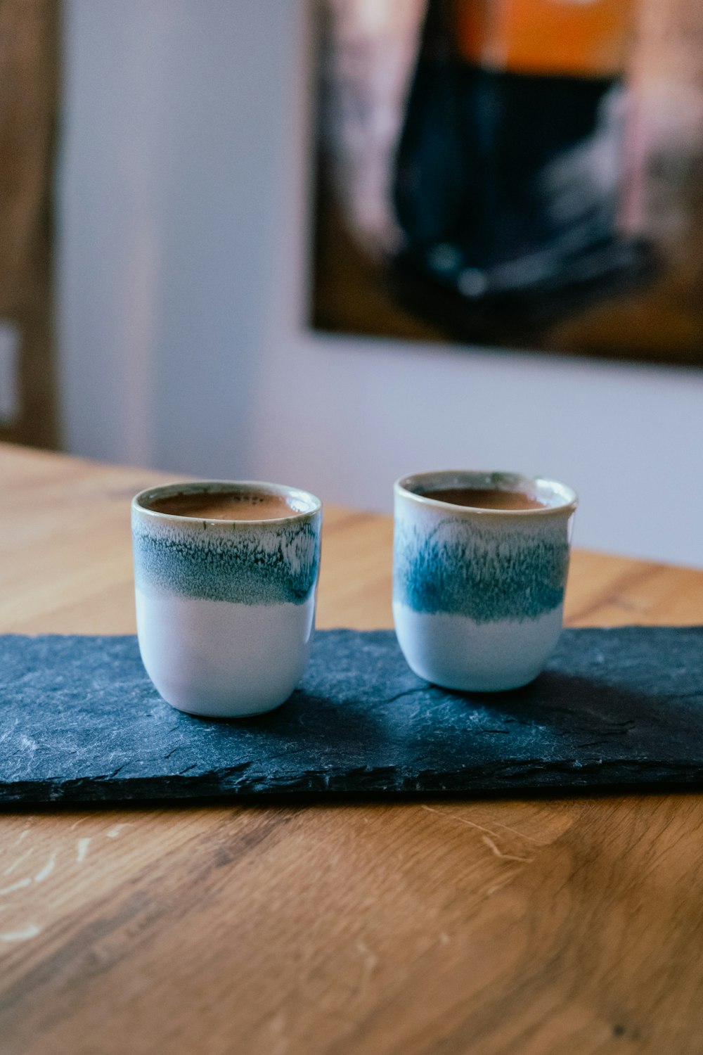two cups sitting on top of a wooden table