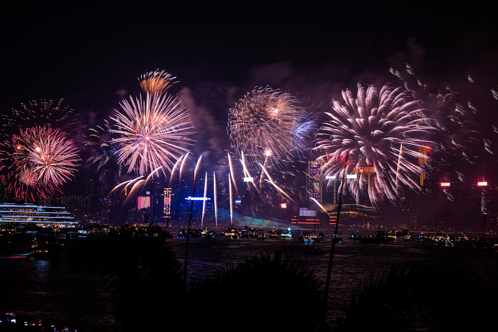 fireworks are lit up in the night sky over a city