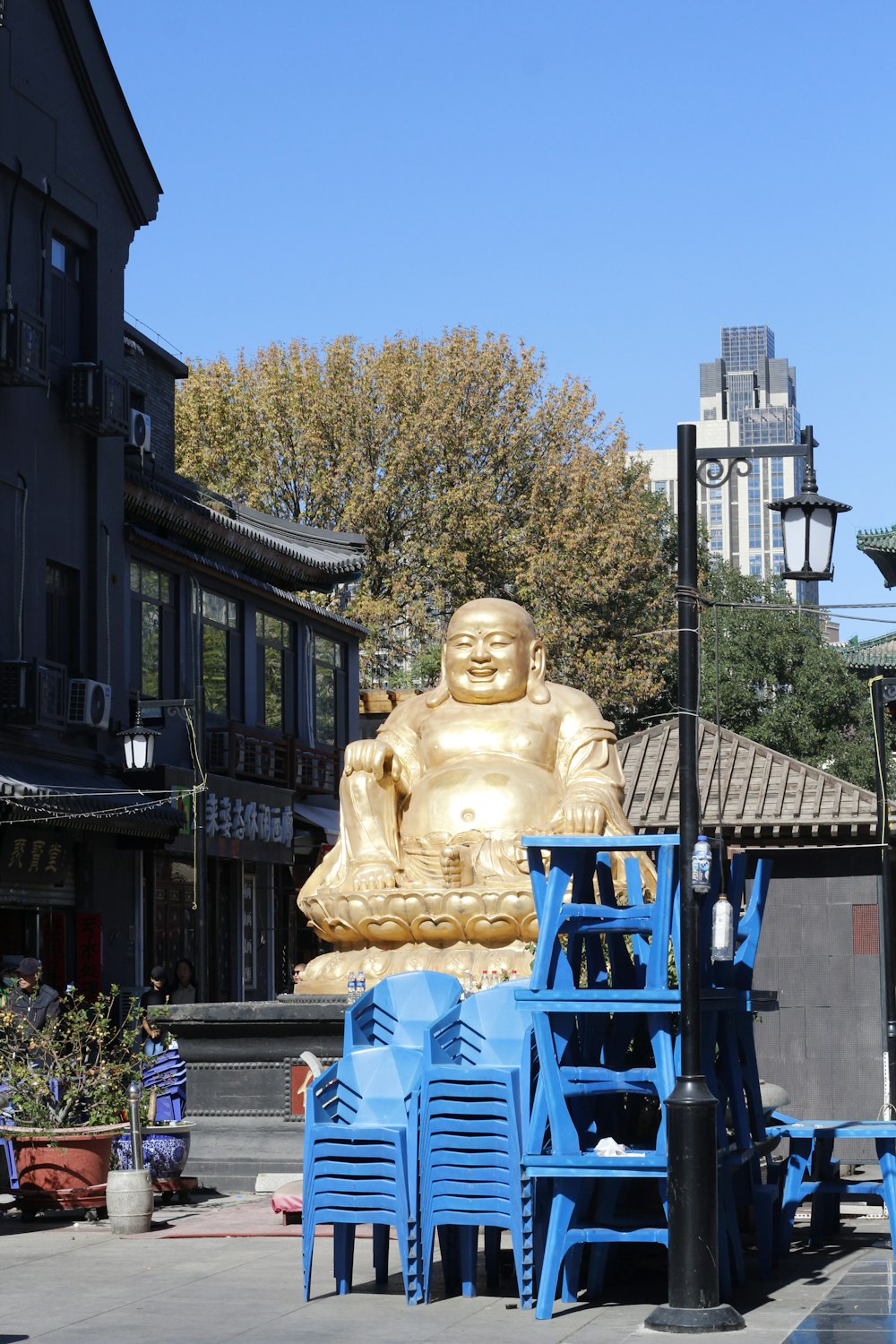 a large golden buddha statue sitting on top of a blue table