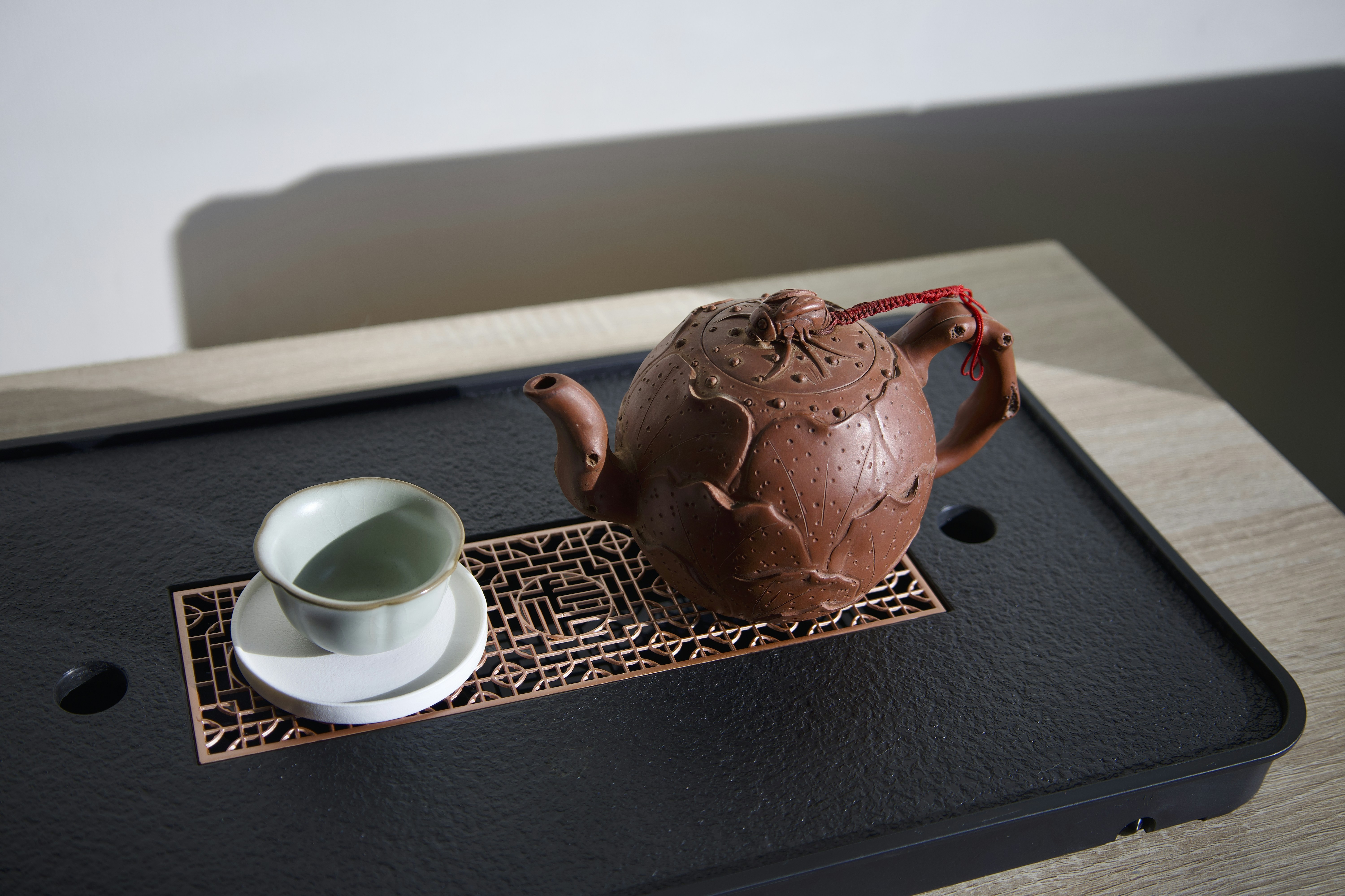 a tea pot and a cup on a tray