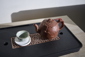 a tea pot and a cup on a tray