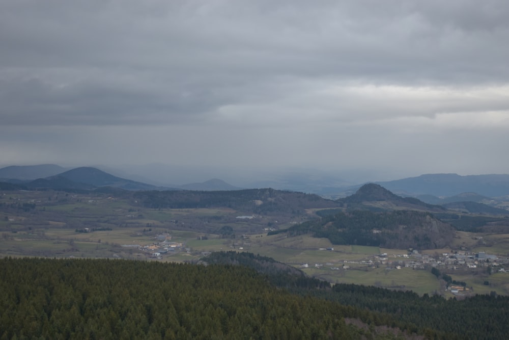 a view of a valley and mountains from a hill