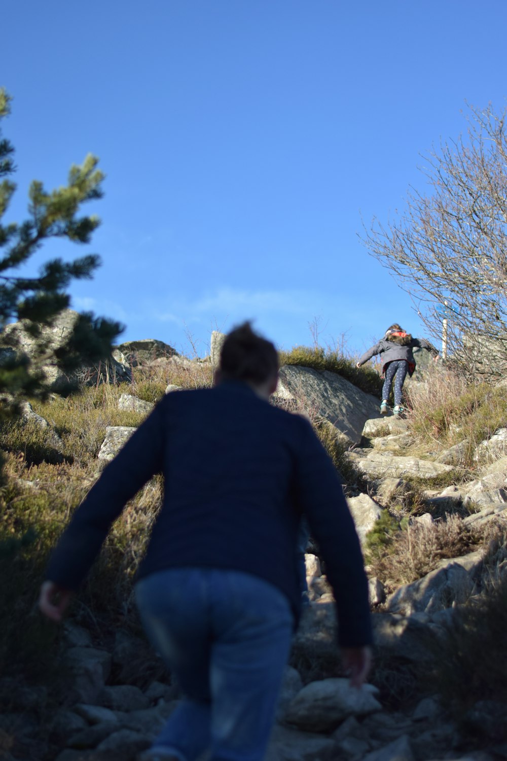 a man is walking up a rocky hill