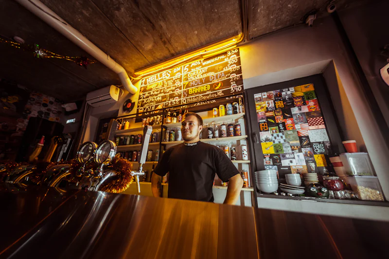 Owner standing behind the counter of his bar