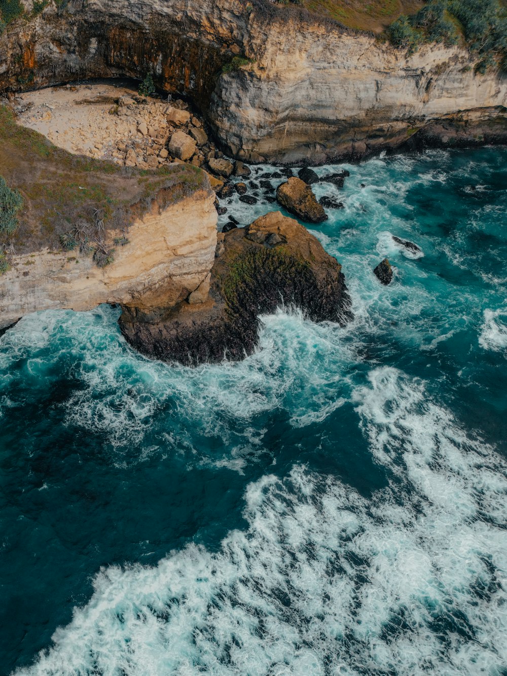 a large body of water next to a rocky cliff