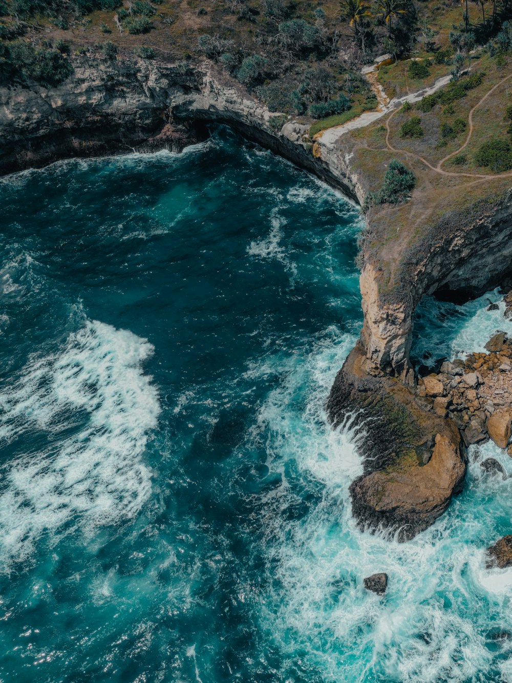 an aerial view of the ocean and cliffs