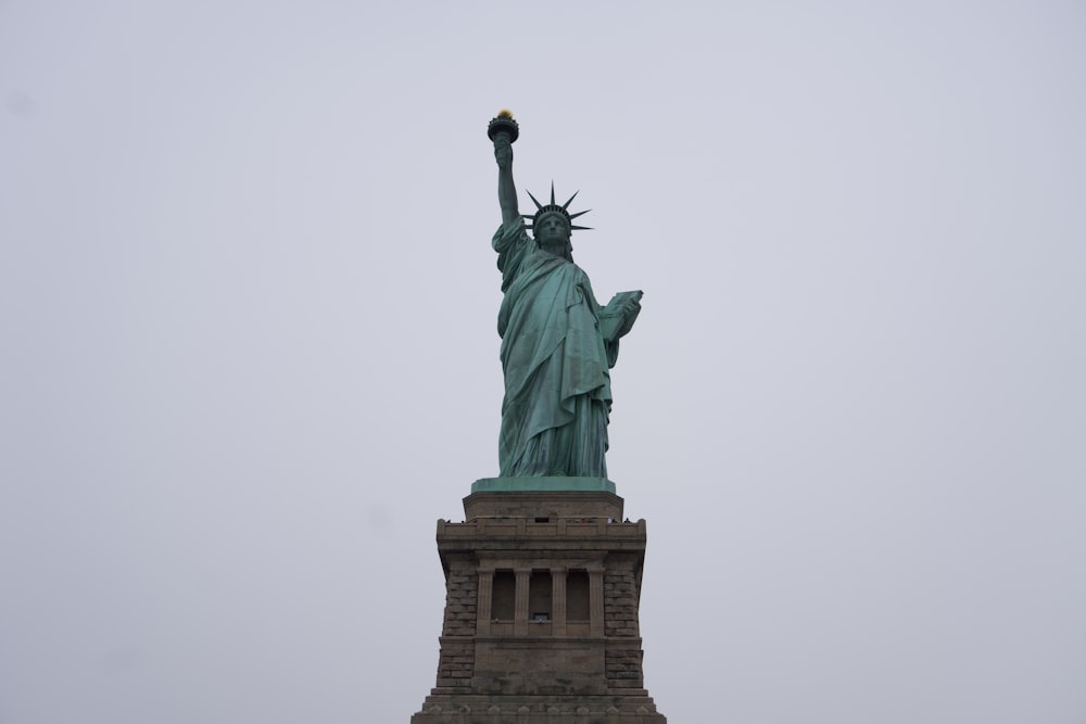 the statue of liberty stands tall on a cloudy day