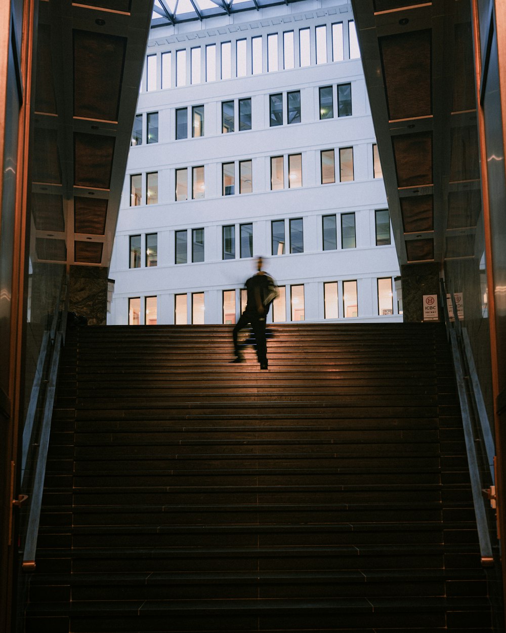 um homem sentado em um conjunto de escadas em frente a um prédio
