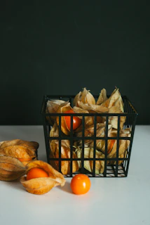 a basket filled with oranges next to a pile of dried fruit