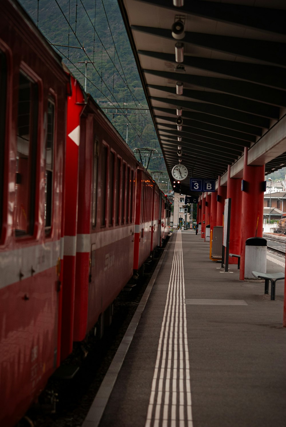 a red train pulling into a train station