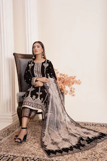a woman sitting on a chair in a black dress