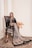 a woman sitting on a chair in a black dress