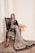 a woman sitting on a chair in a black dress