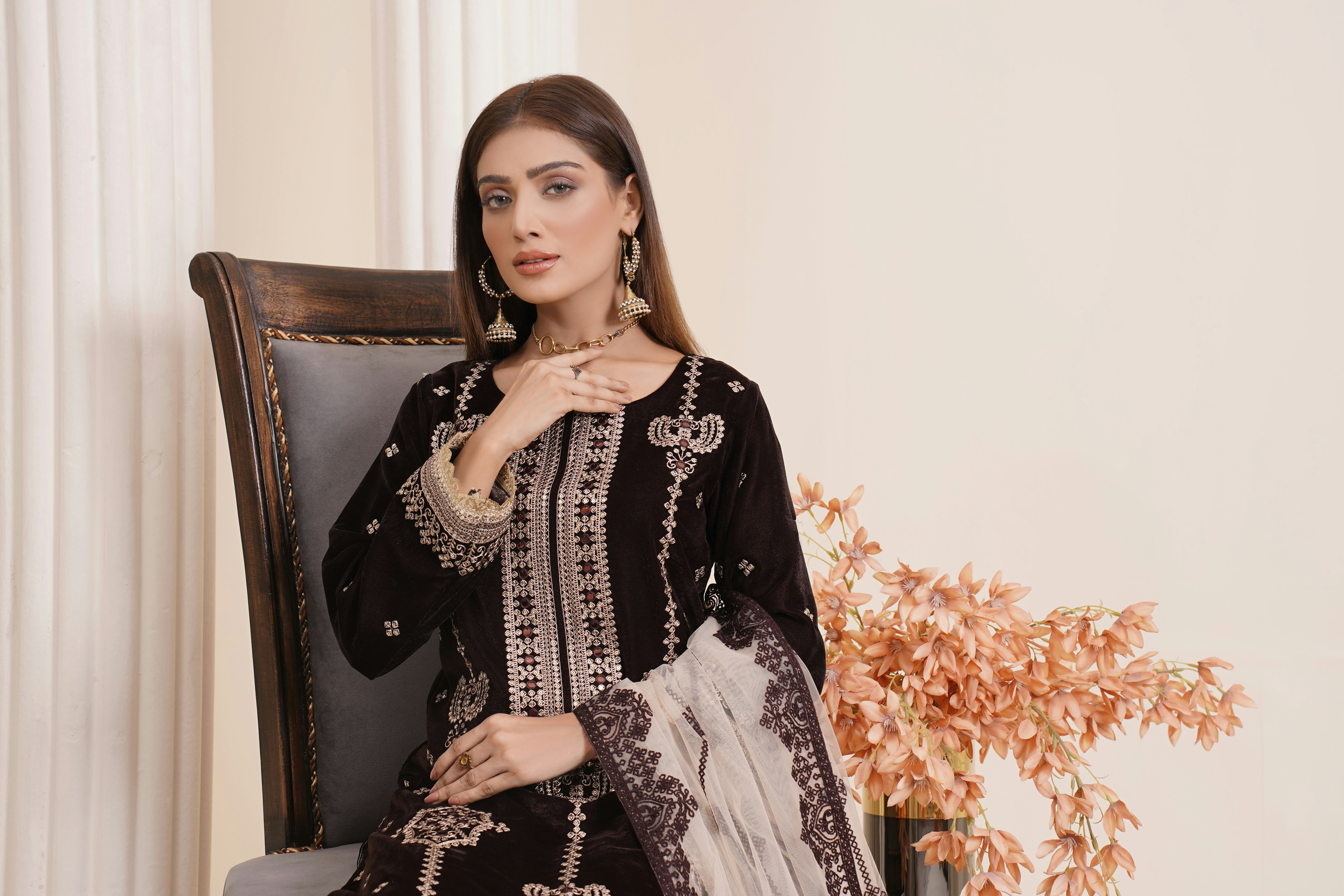 a woman sitting on a chair in a black and white outfit
