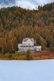 a large white building sitting on top of a lush green hillside